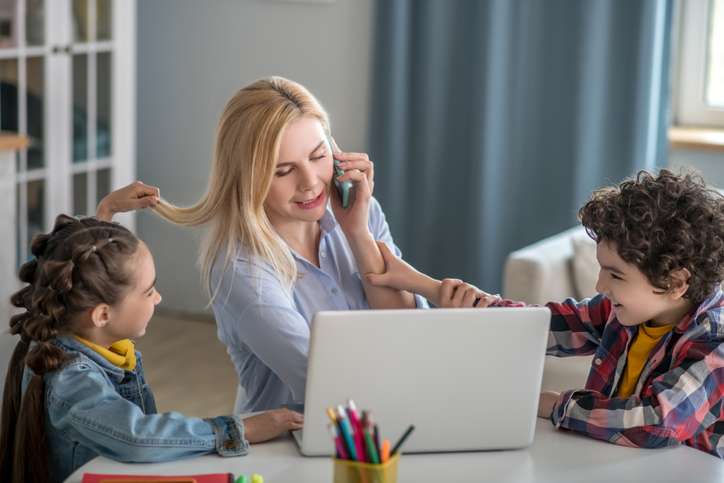 woman tries to focus on work while distracted by her kids