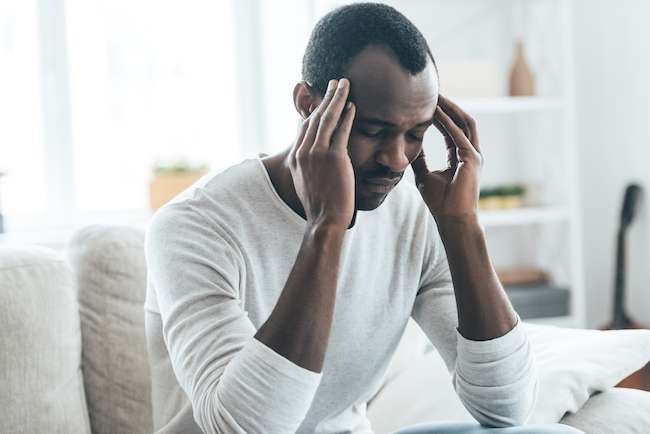 man at desk with hands to head, deeply concentrating to activate his brainpower momentum