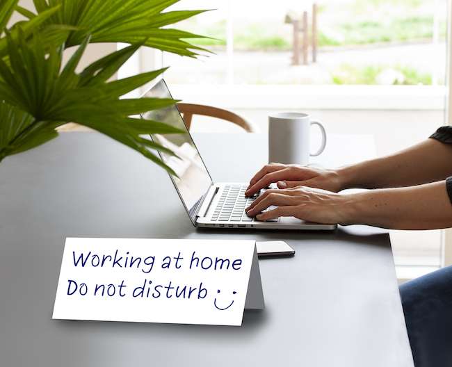 Sign on desk says "Working from home. Do not disturb."