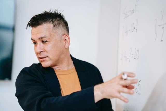 man at whiteboard explaining something