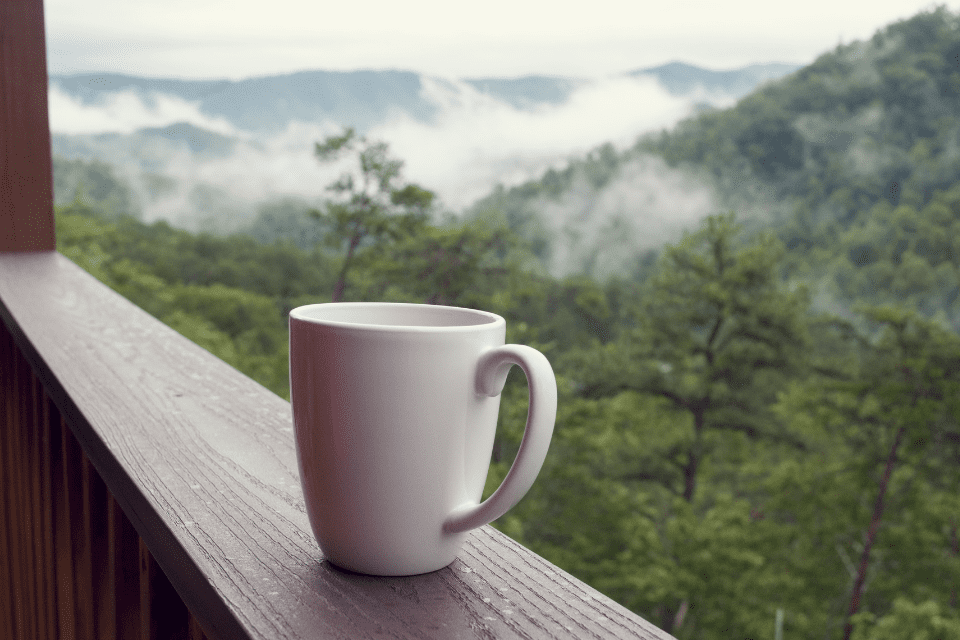 coffee on a ledge by the mountains