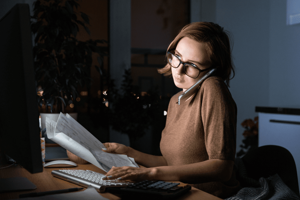 A woman at a laptop working at the office at night