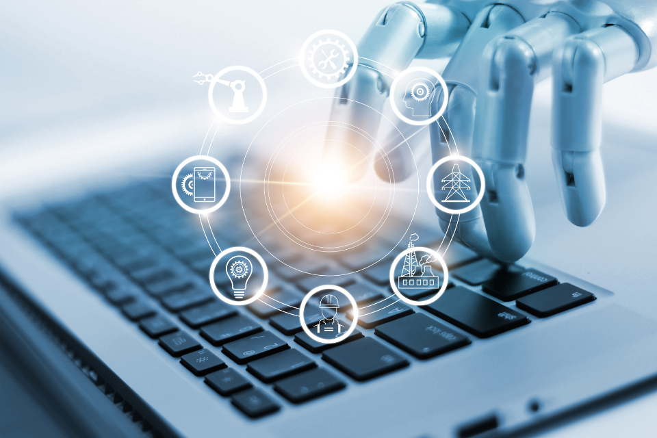 A robot hand on a laptop keyboard