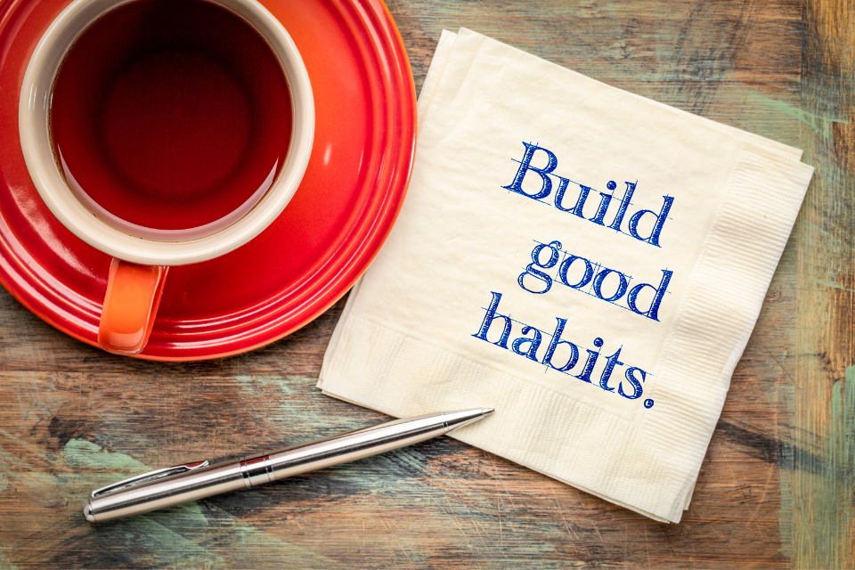 Aerial view of a coffee cup and a napkin that says "Build good habits" on it